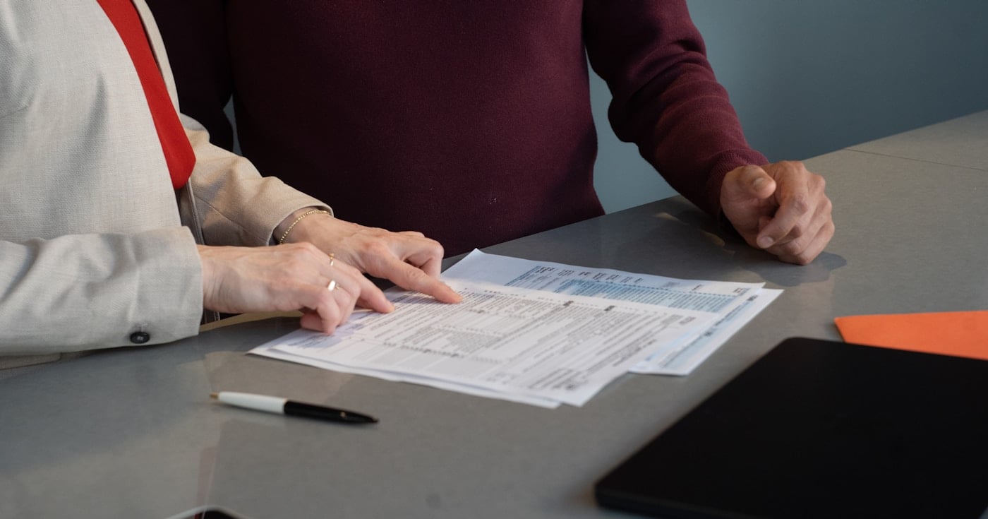 Two professionals reviewing an LLC operating agreement at a conference table